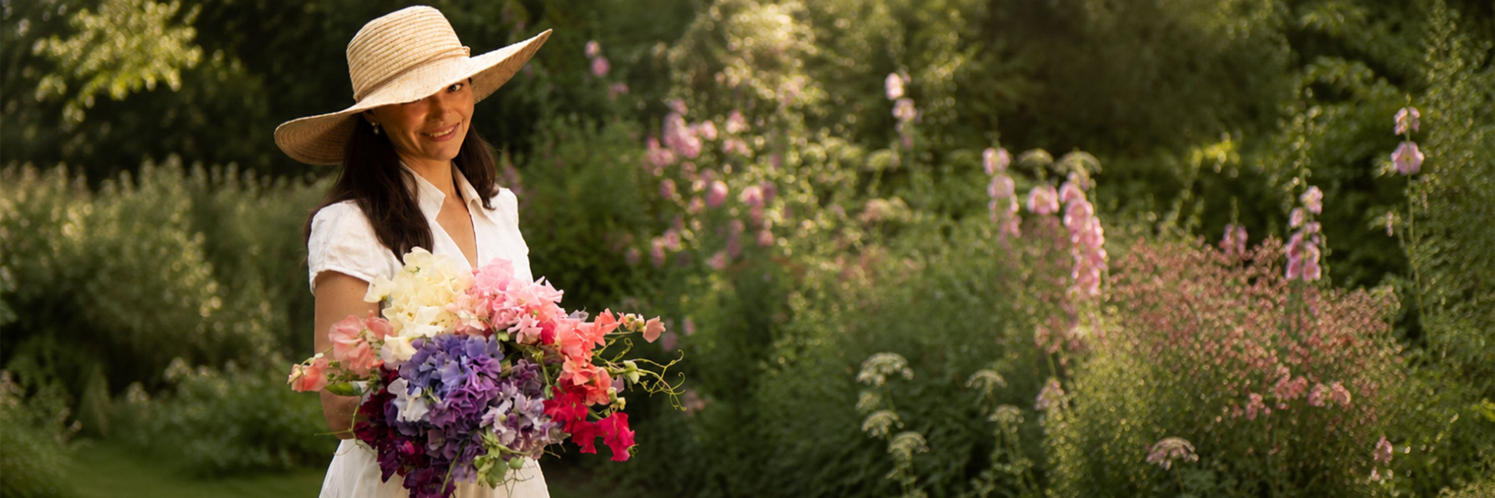 Georgina, founder of Sweet Pea Gardens, holding a bouquet of her favorite sweet pea varieties from the 2026 growing season in the garden.